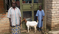 A child with her grandmother and the goat provided by a sponsor